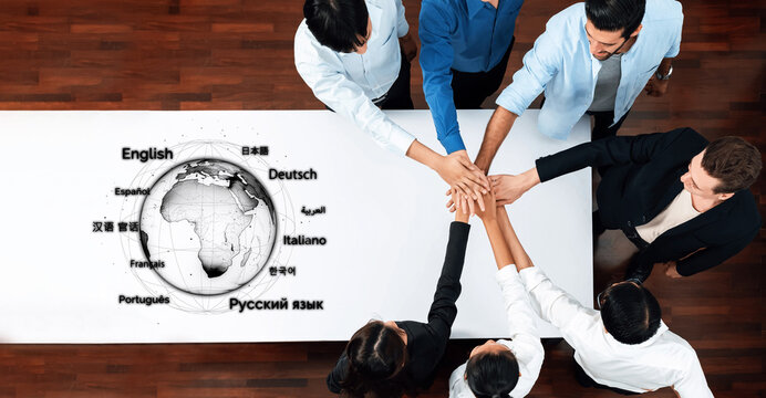 A diverse business team collaborates around a table, promoting multilingual communication strategies with a globe and language icons. They embody teamwork and global connection. Trope