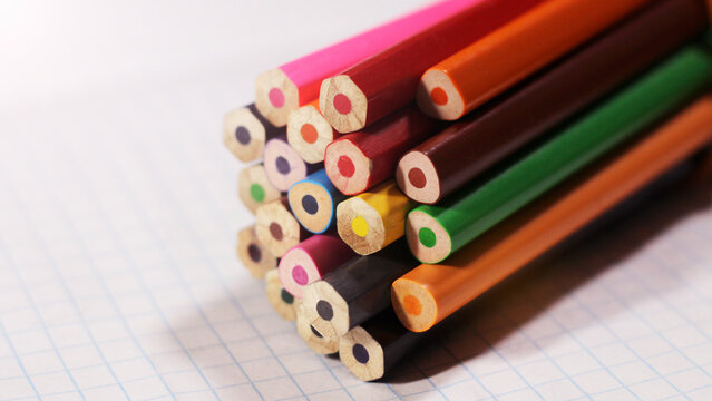Colored pencils on a notebook sheet. School supplies.