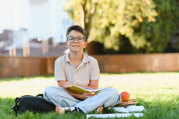 Young boy student with glasses studying outdoors