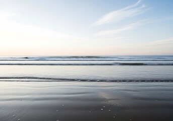 Gentle ocean waves lap onto a sandy beach under a soft, pastel sky, creating a serene and tranquil coastal landscape