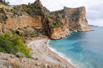 Seascape. Rocky cliffs with calm turquoise waters. Coastal landscape. Secluded bay with a beach surrounded by a vibrant sea. Nature concept.