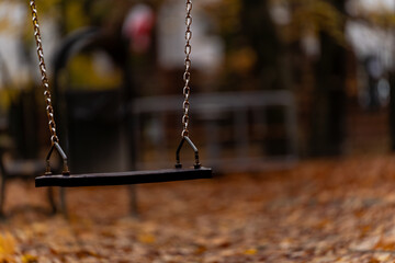 Pusta huśtawka na jesiennym placu zabaw © Kacper