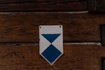 Znak niebieskiego szlaku turystycznego na drewnianej ścianie © Kacper