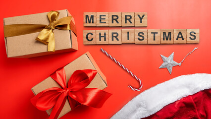 Greeting of Merry Christmas text with a gift box and a candy cane on a red background. Holiday greetings or winter themes. Concept of the Merry Christmas celebration
