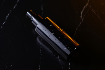 Luxury Black Perfume Bottle with Golden Cap on Dark Surface