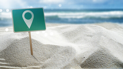 Location mark pointer in the green signboard on the sandy beach with an ocean view and a blue sky background. Concept of travel