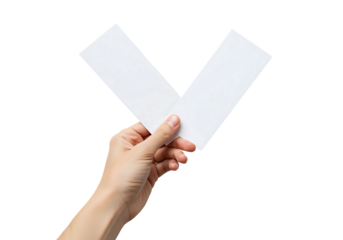 A hand delicately holds a white folded paper shaped like a check mark.