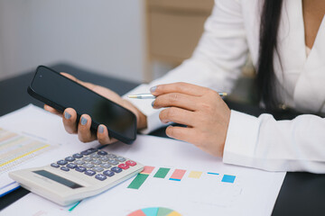 Business finance and accounting concept with woman using smartphone and calculator