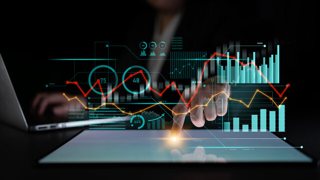 A business professional uses a digital tablet to analyze data trends, showcasing various graphs and metrics in a modern workspace. Ideal for finance and analytics themes. Scalp