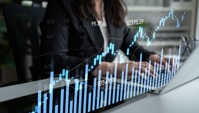 A professional woman engages with financial data on her laptop while surrounded by modern office elements, showcasing trends and performance analytics in a digital format. Scalp