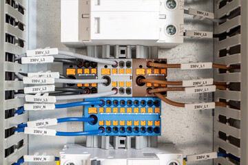 Labeled terminal blocks with 230V wiring in electrical panel
