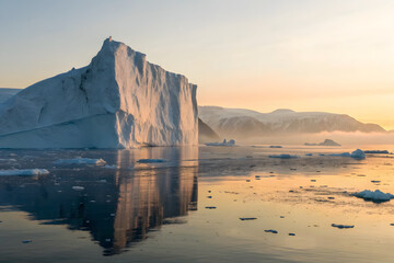 Golden hour tabular iceberg in still Greenland fjord