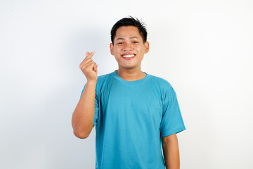 Smiling Man Wearing a Blue Shirt Making a Heart Gesture with His Hands Standing Against a Plain...