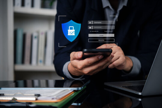 Man login password authentication using smartphone. Secure access data protection cybersecurity. Businessman virtual shield icon privacy technology. Online system internet security office work.