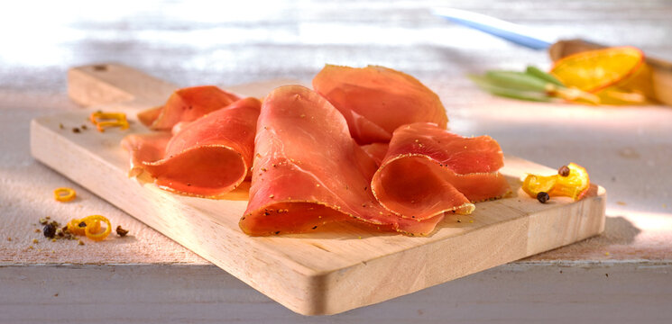 Serrano Schinken mit Orangenpfeffer und Orangenzesten, Spanien, Schinken, scheiben, Holzbrett, 
