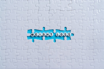 Weight Loss text on light blue background with jigsaw puzzle