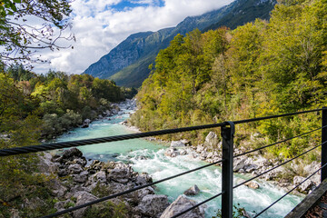 View of the Turquoise Soča River from a Suspension Bridge with Forested Banks and Mountains