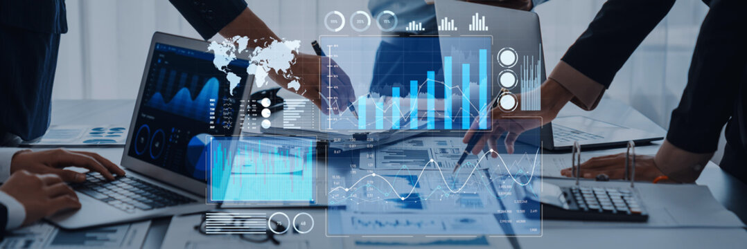 A diverse business team engages in collaborative financial analysis using digital charts and graphs, showcasing innovation and strategy in a modern office environment. Scalp