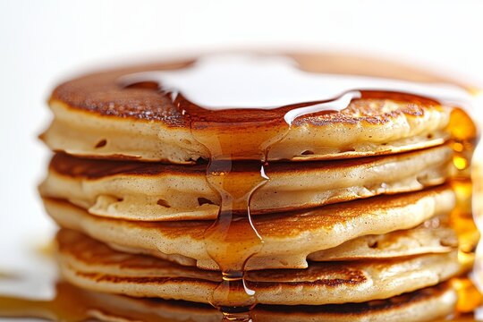 Delicious pancakes stacked high with syrup dripping on top, perfect for breakfast or brunch