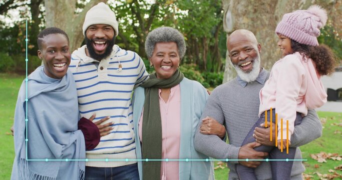 Smiling family standing together in park, wearing knit beanie, pom-pom hat, shawl, blue overlay