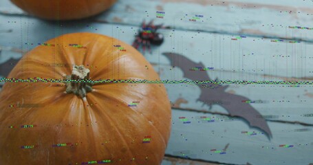 Showing large orange pumpkin sitting on left pale blue planks, with bat cutout, spider, glitch band