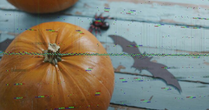 Showing large orange pumpkin sitting on left pale blue planks, with bat cutout, spider, glitch band