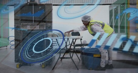 Leaning worker in coveralls hairnet neon vest placing container on sawhorse in plant, copy space