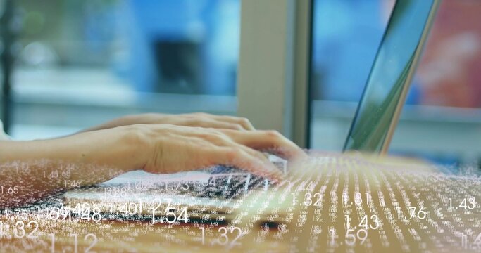 Typing adult hands pressing keys on laptop at desk beside large window, showing data overlay