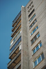 Low angle shot of old residential house with weathered balconies, representing post-soviet architecture.