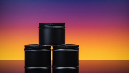 Stack of Three Black Metal Tins with Silver Bands Against Gradient Sunset Sky image photo
