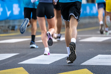 Close up of runners legs competing in an outdoor marathon event in Ljubljana city street