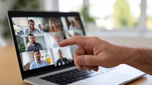 A close-up of a hand pointing at a laptop screen showing a virtual meeting of diverse participants. - Powered by Adobe