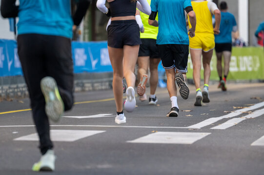 diverse group of runners participating in a marathon outdoors in Ljubljana city wearing athletic gear