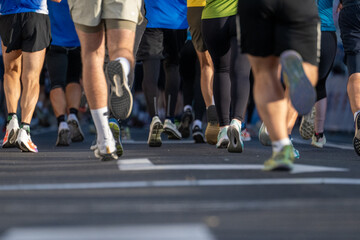 Close up of diverse marathon runners legs running on city road in Ljubljana during race