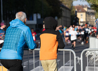 spectators watching diverse runners in a marathon race outdoors in ljubljana city street