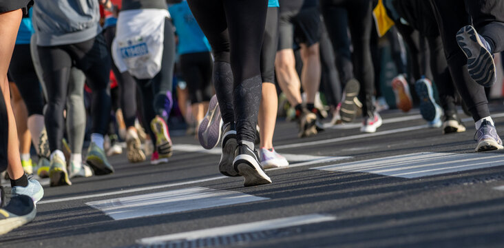 close up of marathon runners wearing athletic shoes running on city street in Ljubljana outdoor event