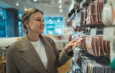 Woman Examining Accessories In Retail Store Shelf.