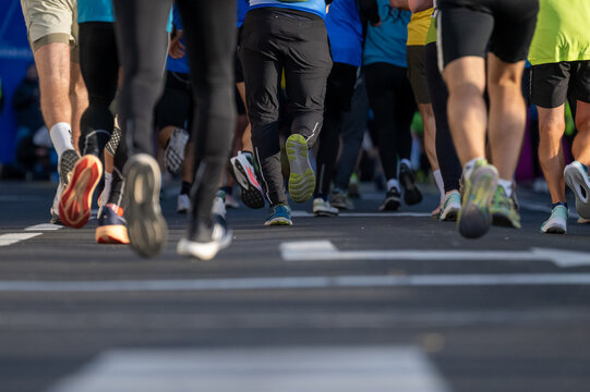 Close up shot of diverse runners participating in a marathon event on city streets in Ljubljana - Powered by Adobe