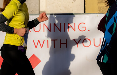 Suportive message for runners participating in a marathon event outdoors in Ljubljana. Running with you