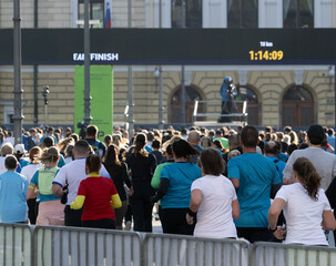 big diverse group of runners nearing marathon finish line in Ljubljana city during daytime
