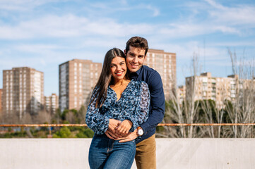Fototapeta premium Happy young couple embracing outdoors, expressing love and connection in an urban setting