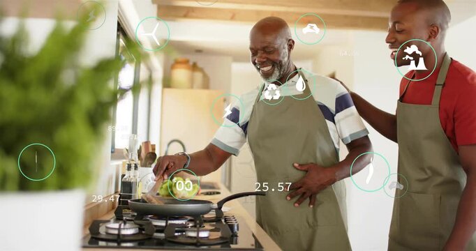 Senior man cooking on stovetop, son leaning placing hand helping, green icons drifting around cooks