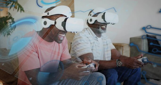 Father and son pressing start button, leaning in and playing VR game with headsets, holographic UI