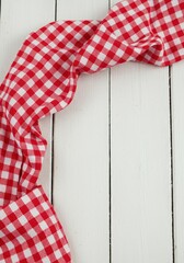Classic red and white gingham picnic cloth draped over rustic white wooden planks, evoking summer, outdoor dining, and simple pleasures, holiday, home, texture