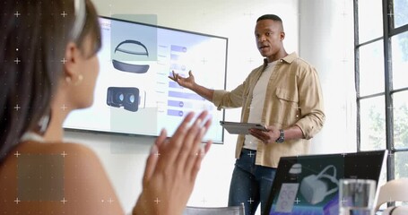 Male presenter demoing VR, pointing to sliders animating while holding tablet, attendee clapping