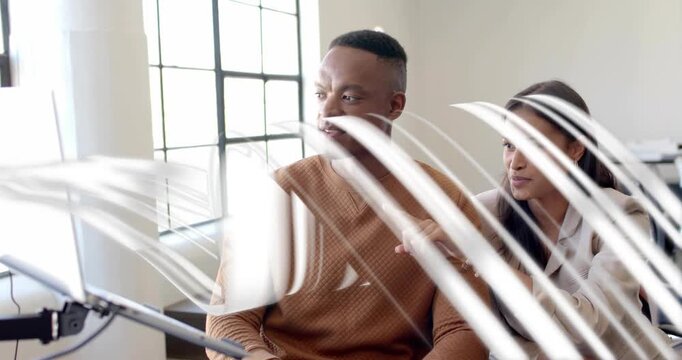 Woman pointing at display with white overlays, guiding man manipulating screen reviewing business