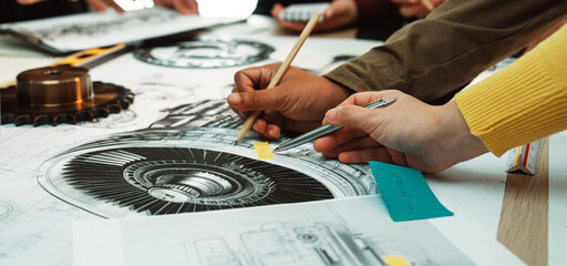 Engineers engage in a dynamic design session, surrounded by blueprints and sketches. The focus is on collaboration and creativity in developing technical solutions. SACTR