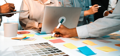 A dynamic brainstorming session featuring a diverse team in a modern office. Participants engage with colorful sticky notes and laptops to develop innovative ideas and strategies. SACTR