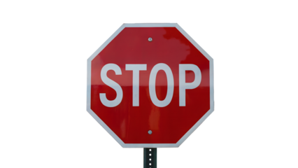 A close up of a red stop sign with white lettering on a pole against a black background in the day time