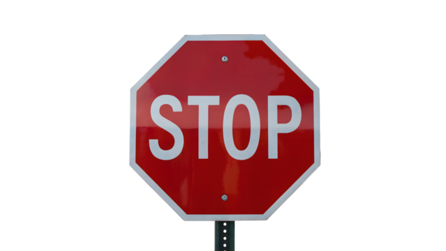 A close up of a red stop sign with white lettering on a pole against a black background in the day time